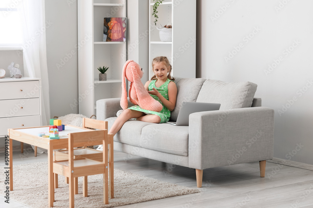 Little girl with toy having online psychologist session at home