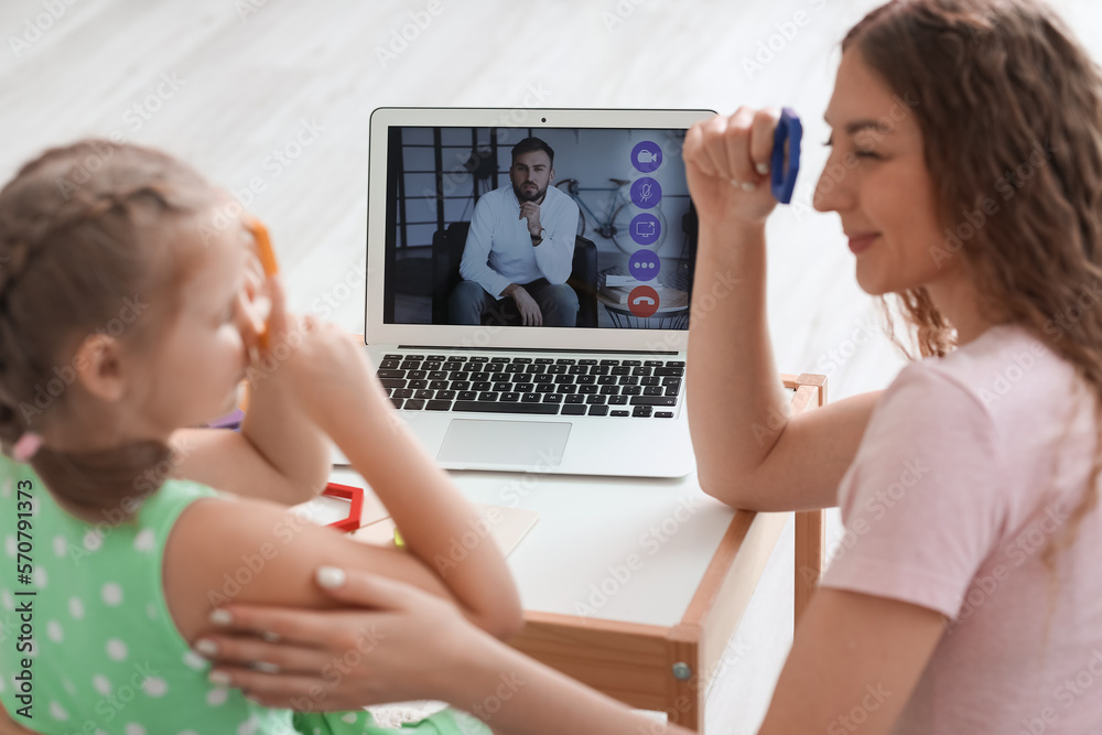 Little girl and her mother with toys having online psychologist session at home