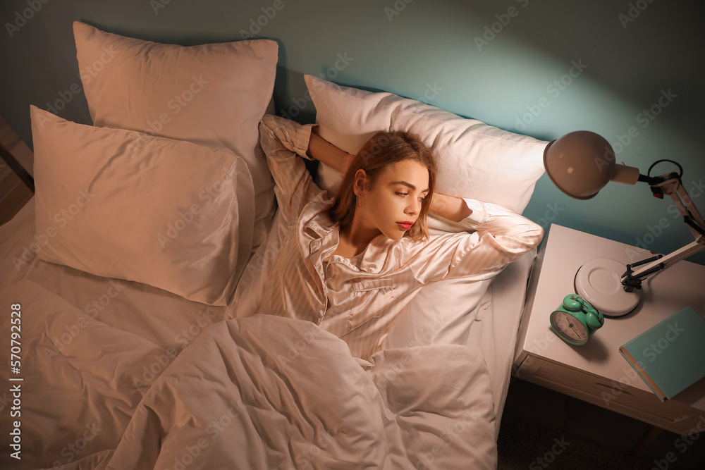 Young woman cannot sleep in bedroom at night