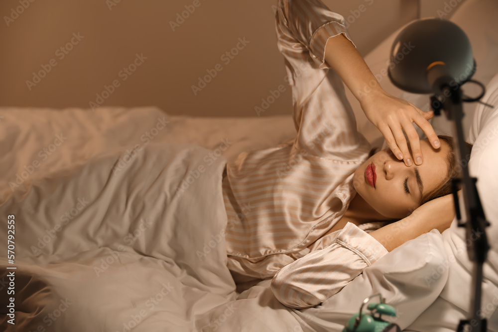 Young woman lying in bed at night