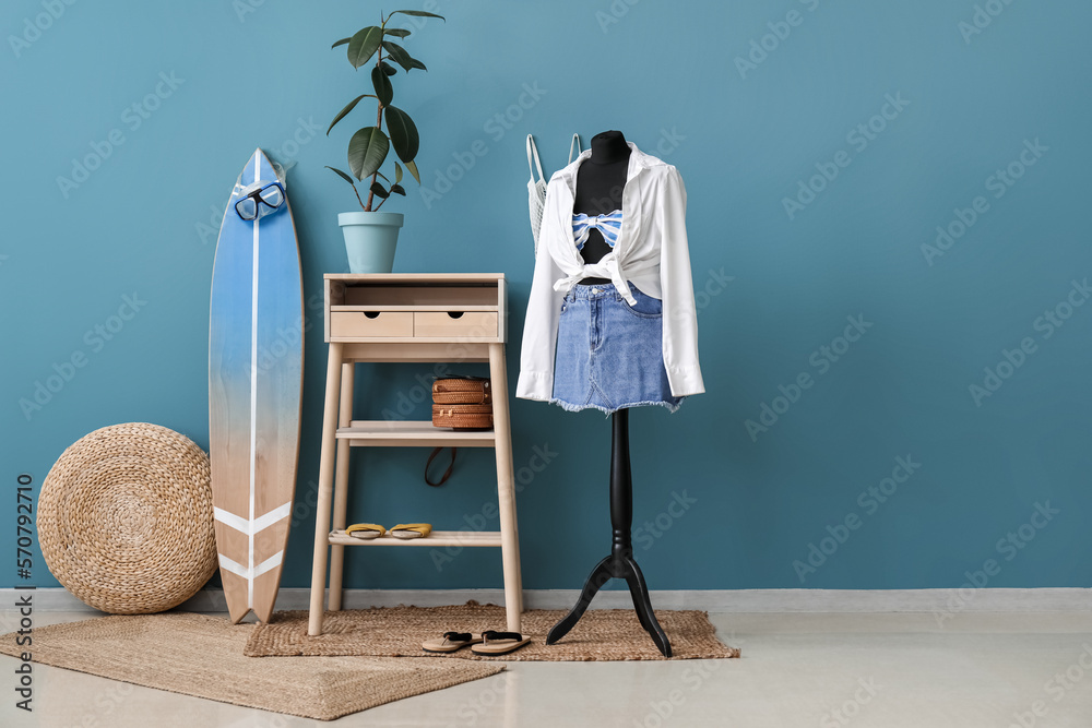 Interior of fashion designers studio with mannequin, clothes and surfboard