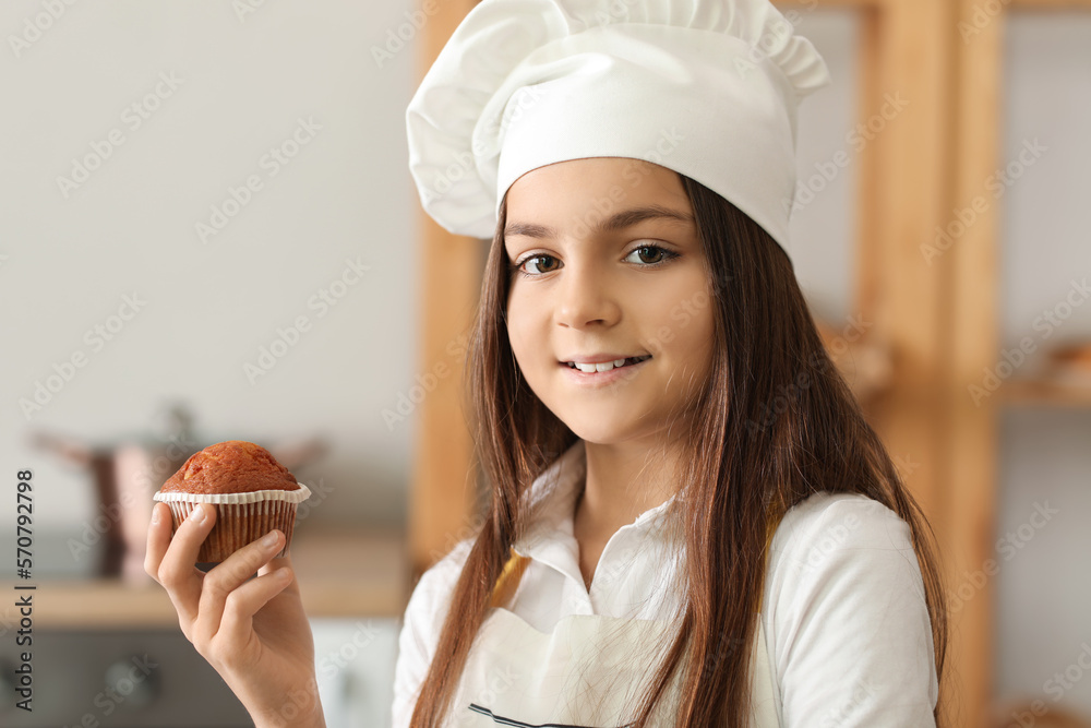 Little baker with tasty cupcake in kitchen, closeup