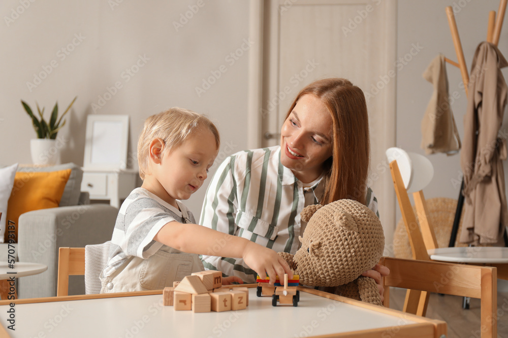 Mother and her little son playing with toys at home