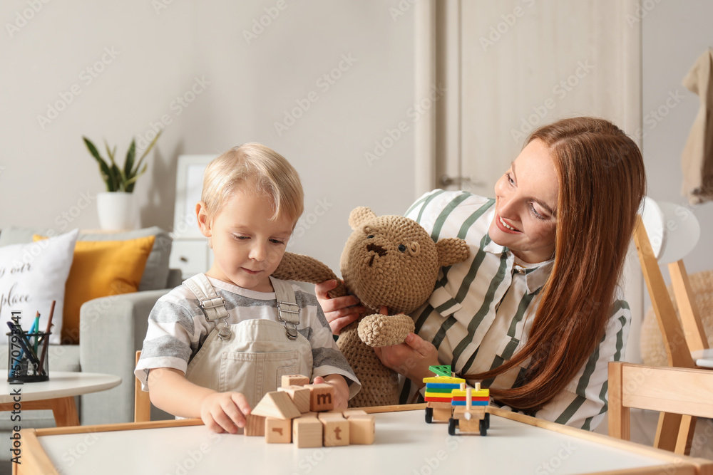 Mother and her little son playing with toys at home