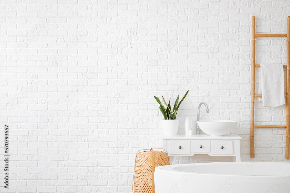 Interior of light bathroom with sink and ladder