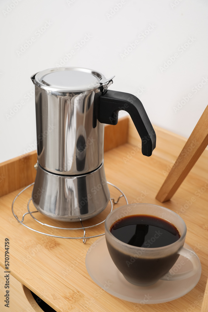 Geyser coffee maker and cup of espresso on nightstand table