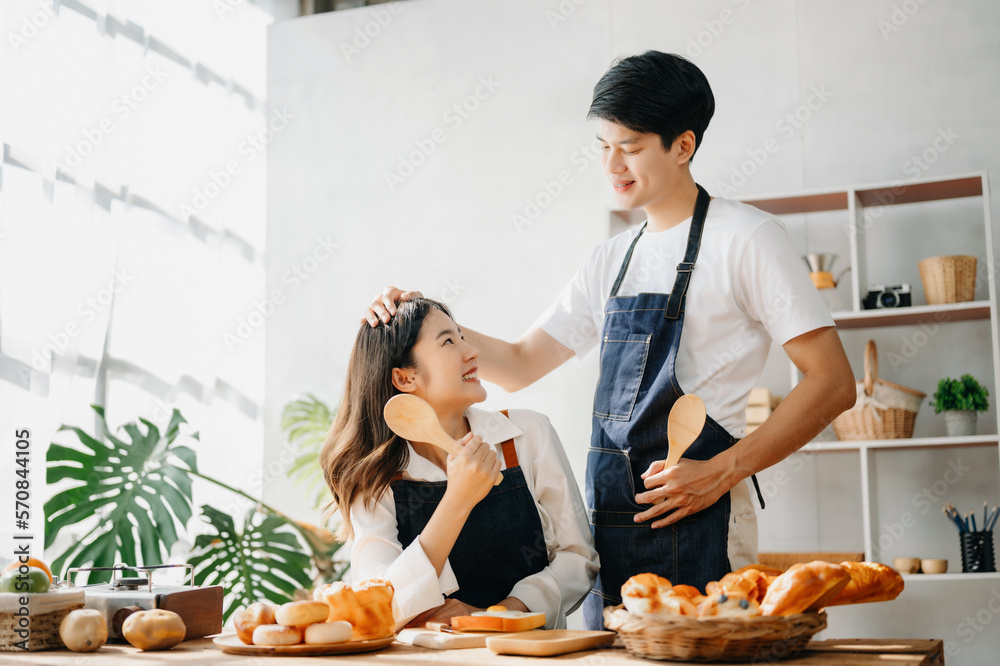 Image of newlywed couple cooking at home. Asia young couple cooking together with Bread and fruit in