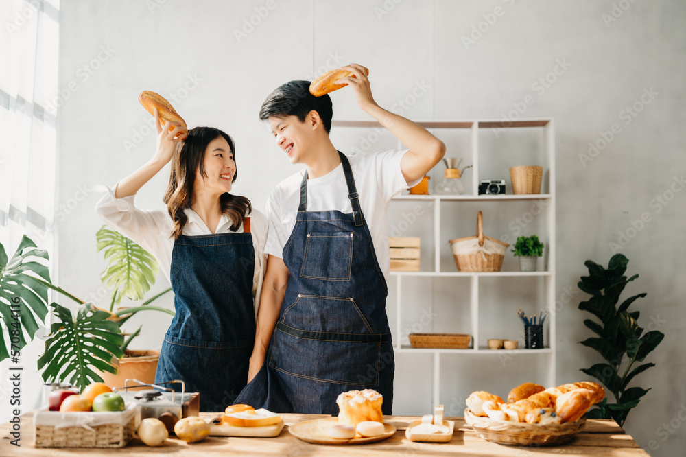 Asia lovers or couples cooking in kitchen with full of ingredient with Bread and fruiton table.Valen