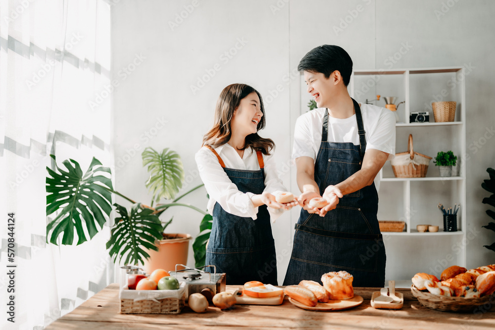 Asia lovers or couples cooking in kitchen with full of ingredient with Bread and fruiton table.Valen