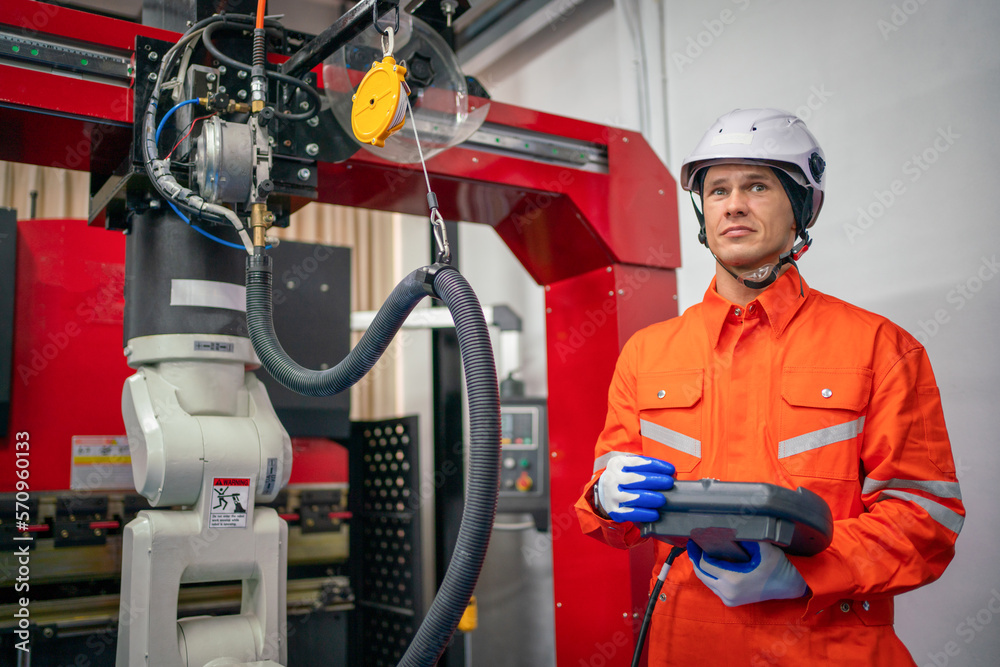 Engineers mechanic using computer controller Robotic arm for welding steel in steel factory workshop