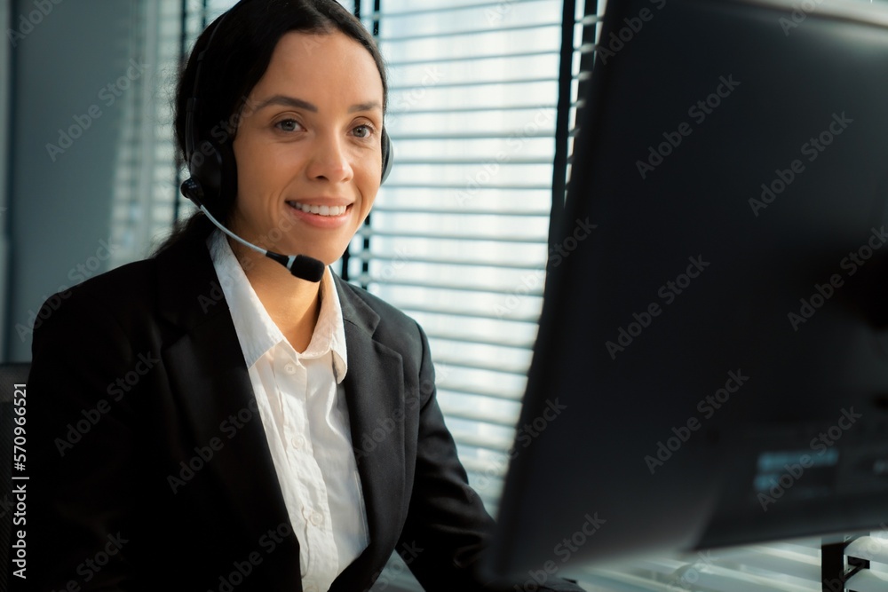 Competent female operator working on computer and talking with clients. Concept relevant to both cal