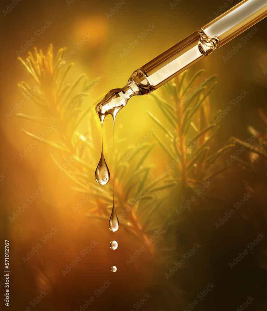 Cosmetic pipette with drops close-up on a blurred natural background with bokeh