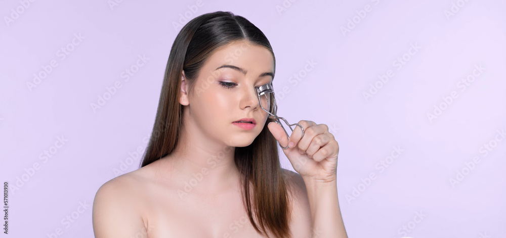 Closeup happy young charming brunette holding eyelash curler in her hand as makeup accessory. Beauti