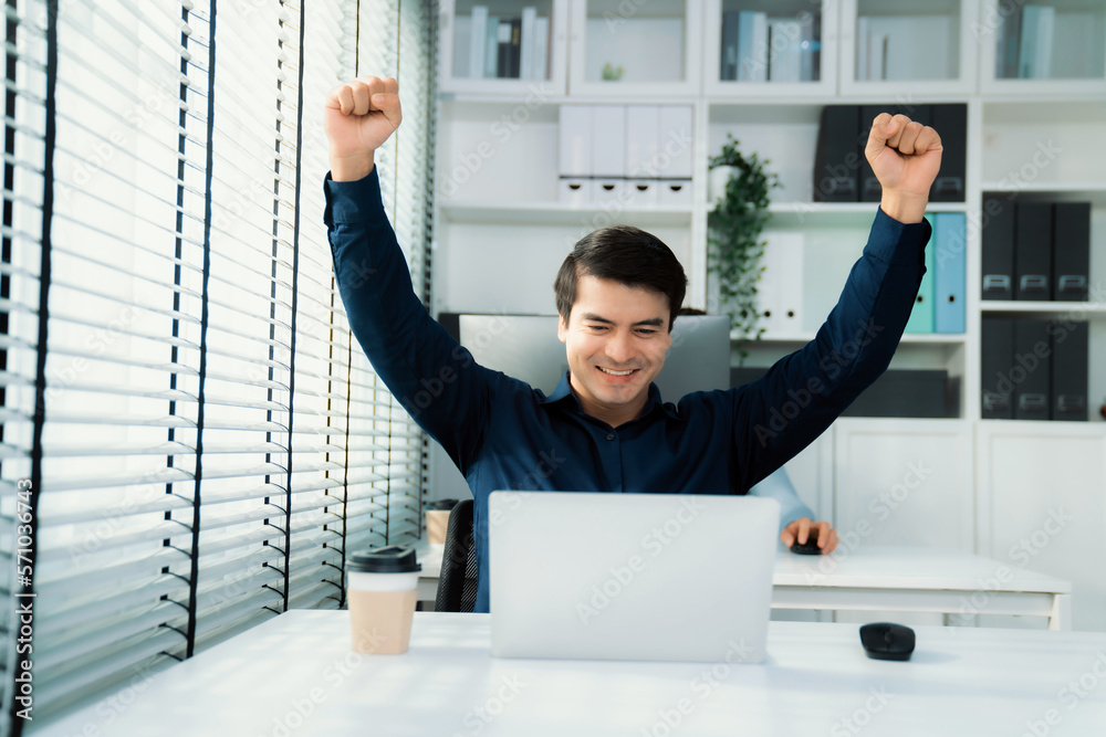 Young male employee receives a promotion, good news or finished his task and overjoyed for being a c