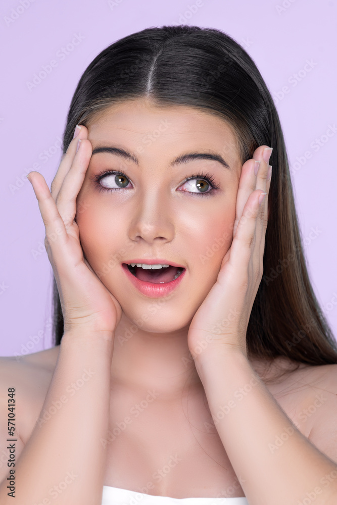 Portrait of young brunette with long hair and flawless skin with hand gesture for beauty and cosmeti