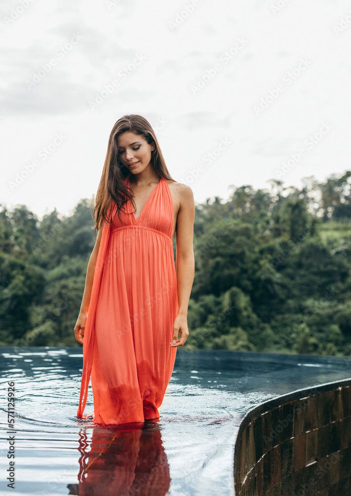 Attractive young female in swimming pool at holiday resort