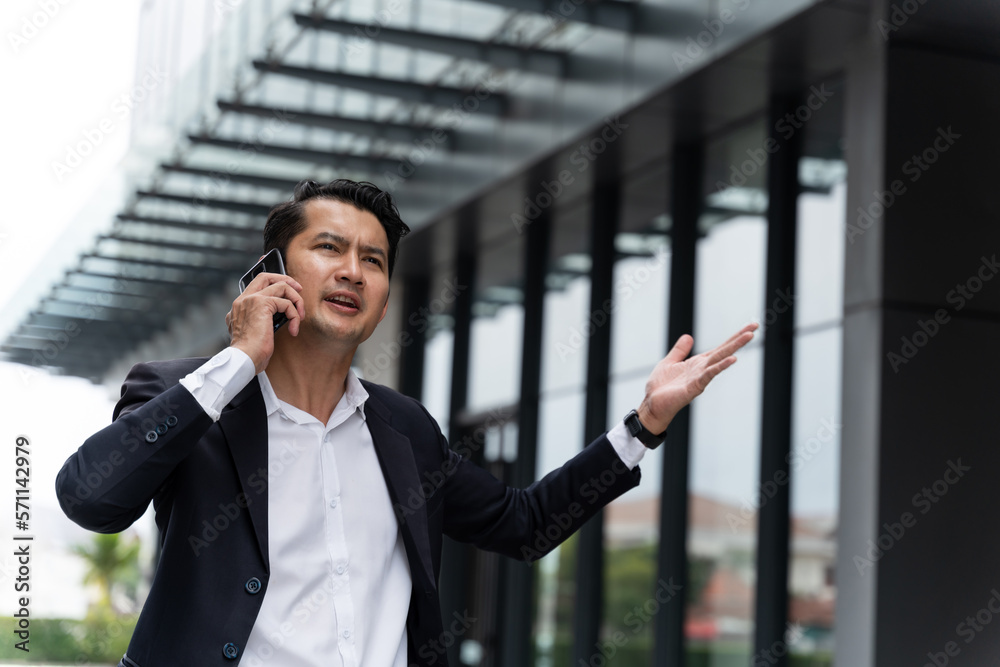 Asian businessman screaming while talking on the phone. insurance concept.