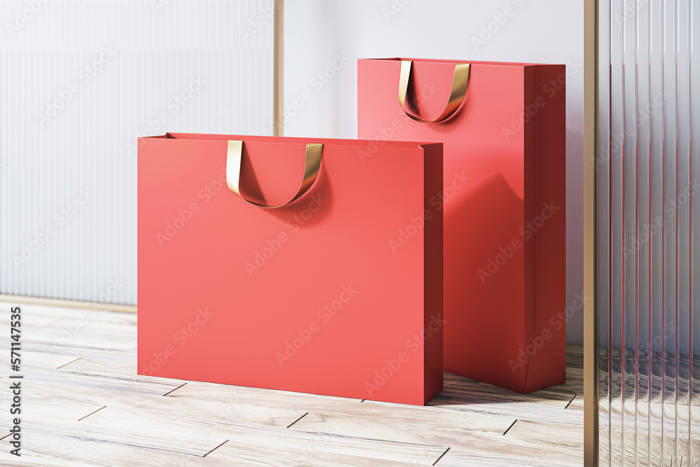 Perspective view on blank red paper shopping bags with space for your brand name or text on wooden f