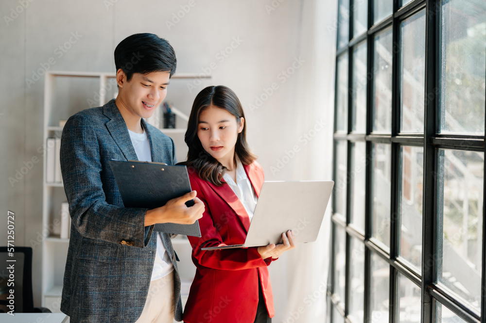 Female discussing new project with male colleague. Mature woman talking with young man in office.