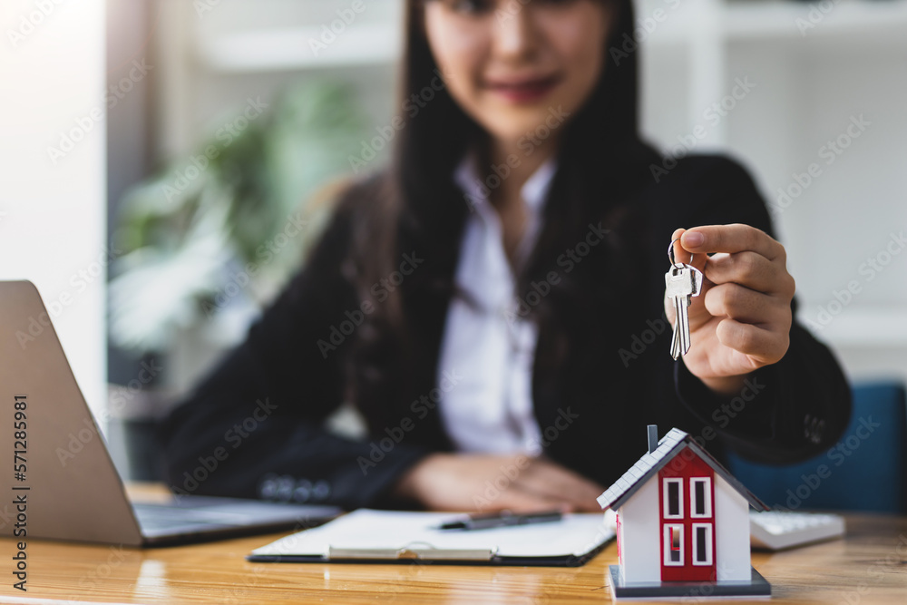 Real estate agent showing house keys, The concept of buying and selling homes and rental homes.