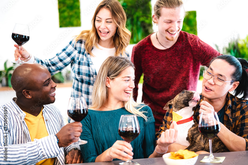 Trendy people toasting red wine on dinner party mood - Multiracial friends having fun together with 