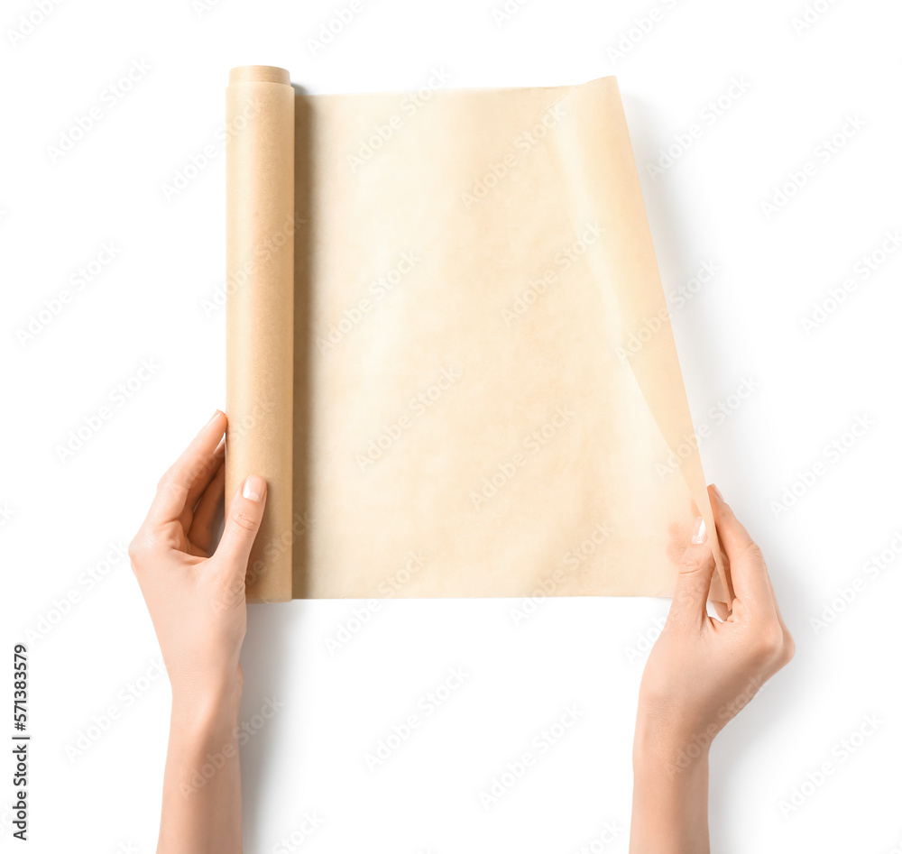 Female hands with roll of baking paper on white background