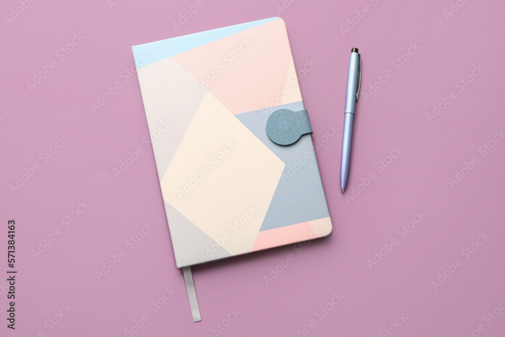 Notebook and pen on lilac background