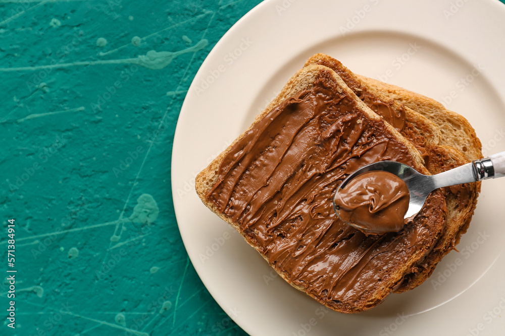 Plate of tasty toasts with hazelnut butter on color background, closeup