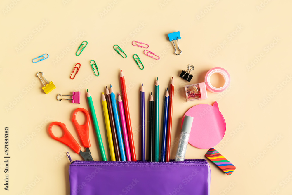 Case with colorful pencils and different stationery on color background