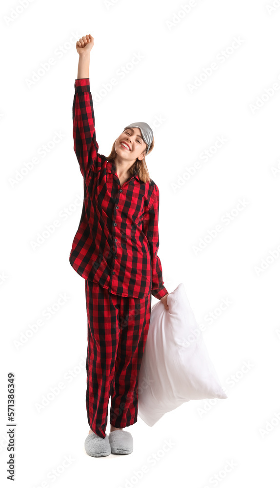 Young woman in checkered pajamas with pillow on white background