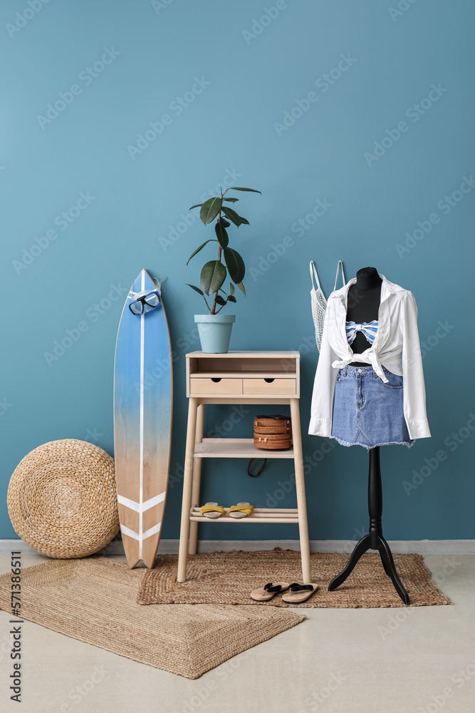 Interior of fashion designers studio with mannequin, clothes and surfboard