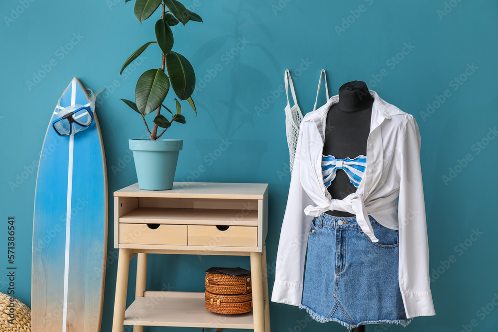 Interior of fashion designers studio with mannequin, clothes and surfboard