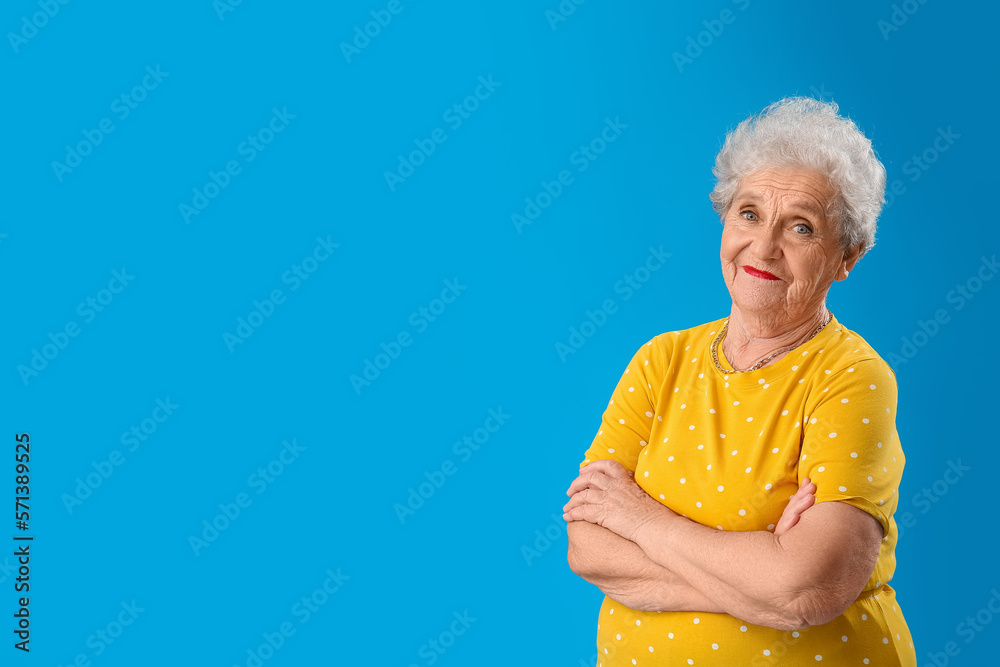 Senior woman in yellow t-shirt on blue background