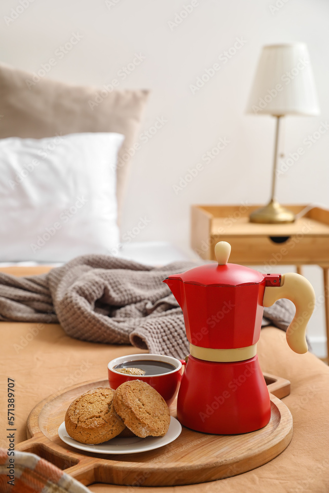 Plate with geyser coffee maker, delicious cookies and cup of espresso on bed