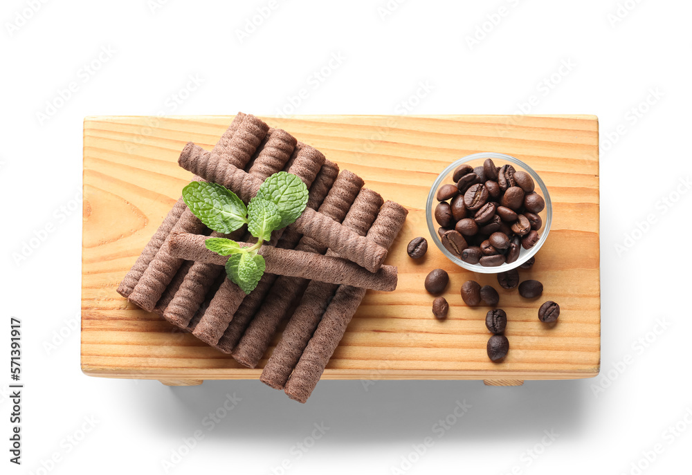 Board with delicious chocolate wafer rolls, coffee beans and mint isolated on white background