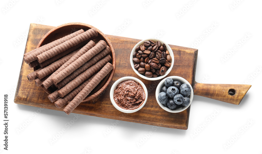 Board with delicious chocolate wafer rolls, coffee beans and blueberries isolated on white backgroun