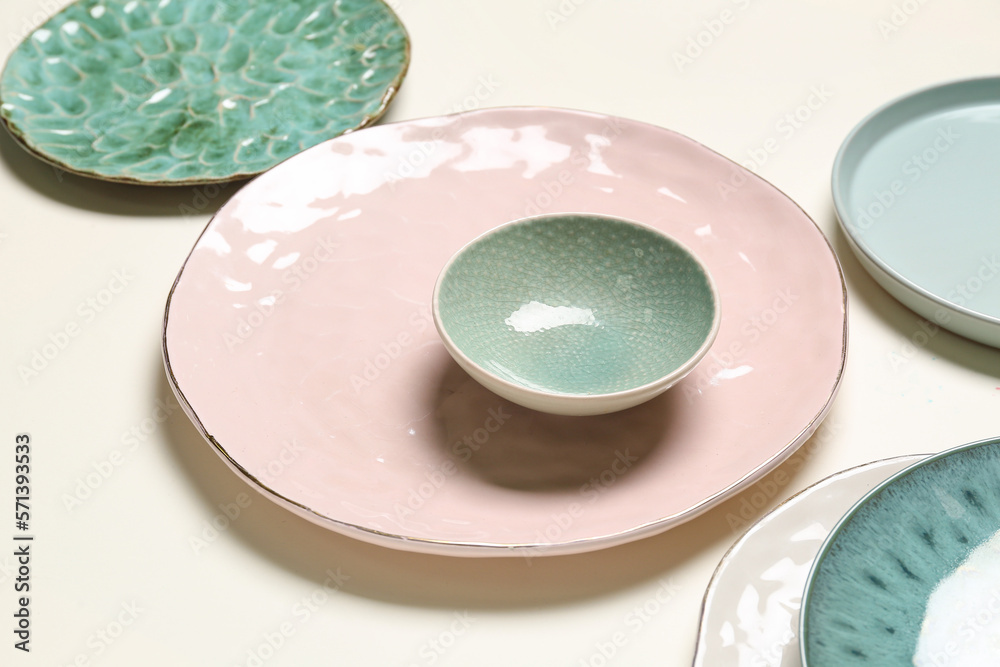 Set of stylish ceramic plates on light background, closeup