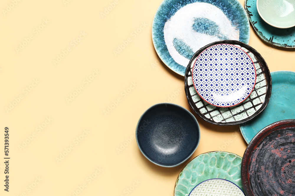 Set of different ceramic plates on color background