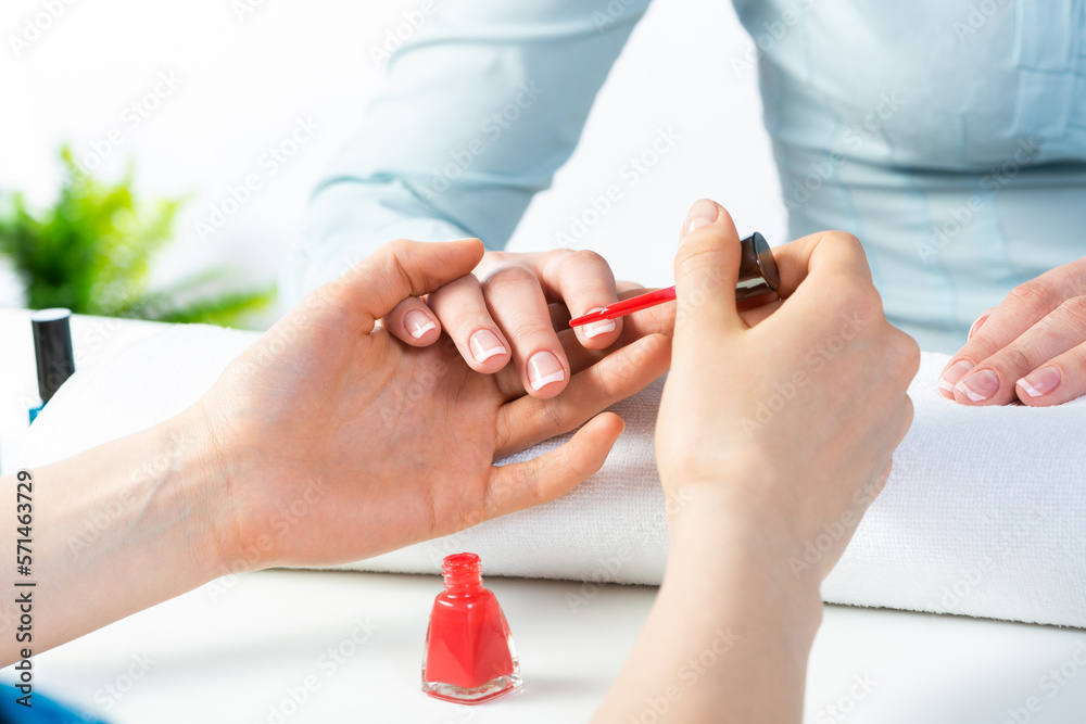 Manicurist working with clients nails at table