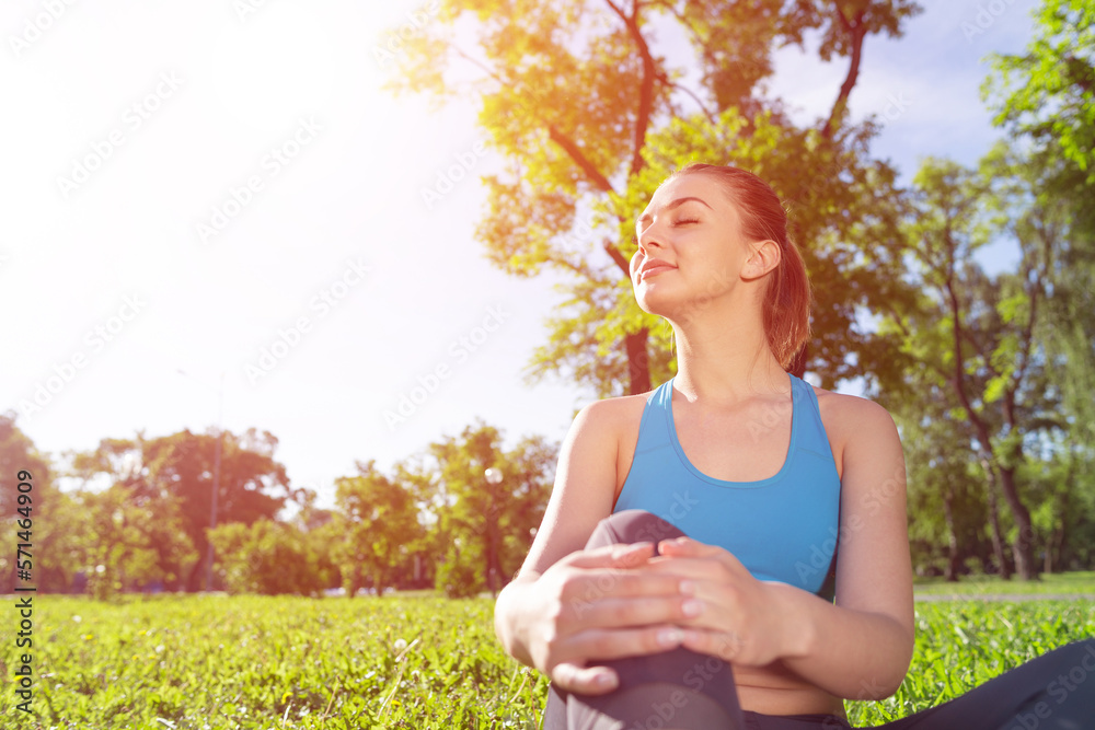 Beautiful smiling girl in sportswear relax in park