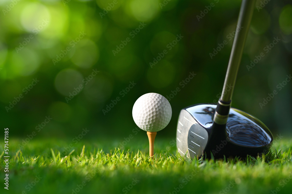 Close-up golf ball on tee with golf drivers at golf course.