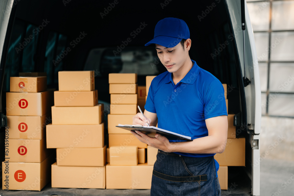 Happy delivery man standing with arms crossed near van outside the warehouse. This is a freight tran