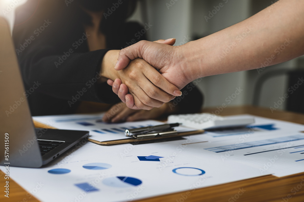 Businesswoman shaking hands with partner after business strategy planning meeting.