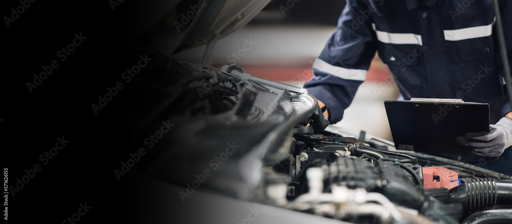 Mechanic works on the engine of the car in the garage. Repair service. Concept of car inspection ser