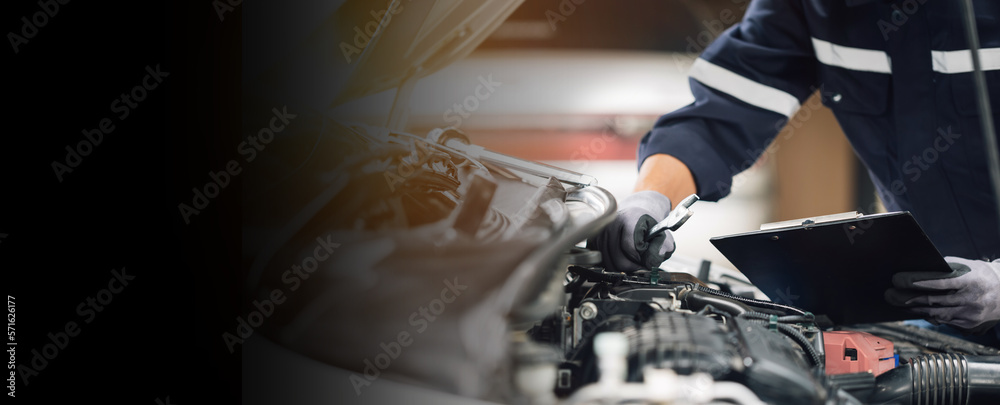 Mechanic works on the engine of the car in the garage. Repair service. Concept of car inspection ser