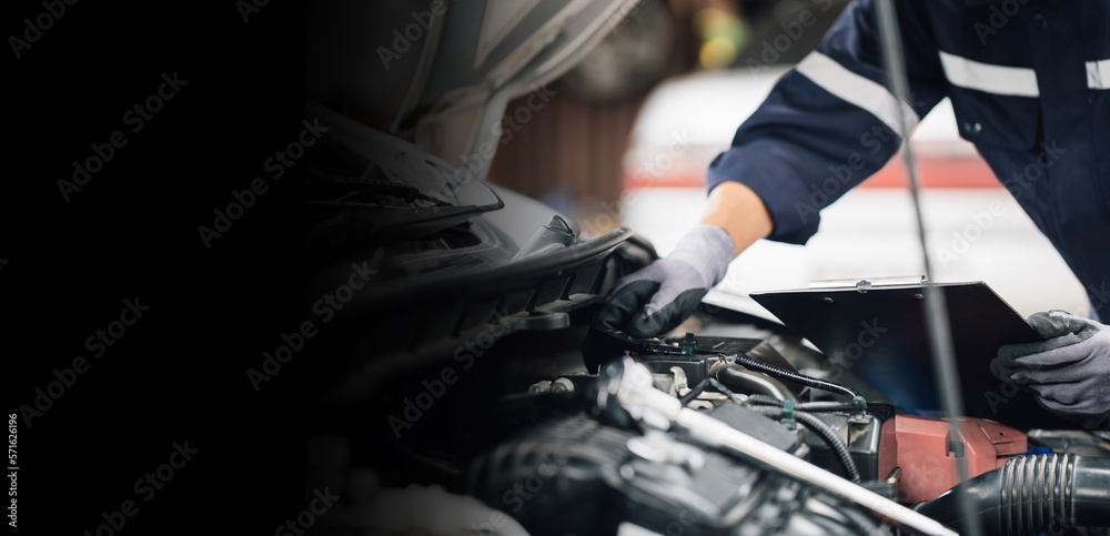 Mechanic works on the engine of the car in the garage. Repair service. Concept of car inspection ser