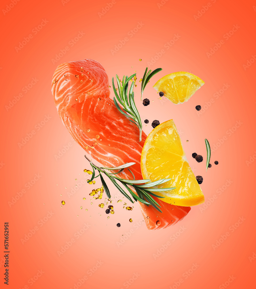 Juicy slice of fresh salmon with ingredients closeup on a red background