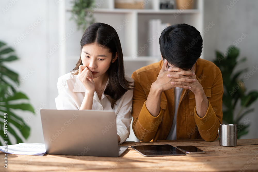 Stress, anxiety and worry with a young couple struggling with finance, debt and the home budget in t