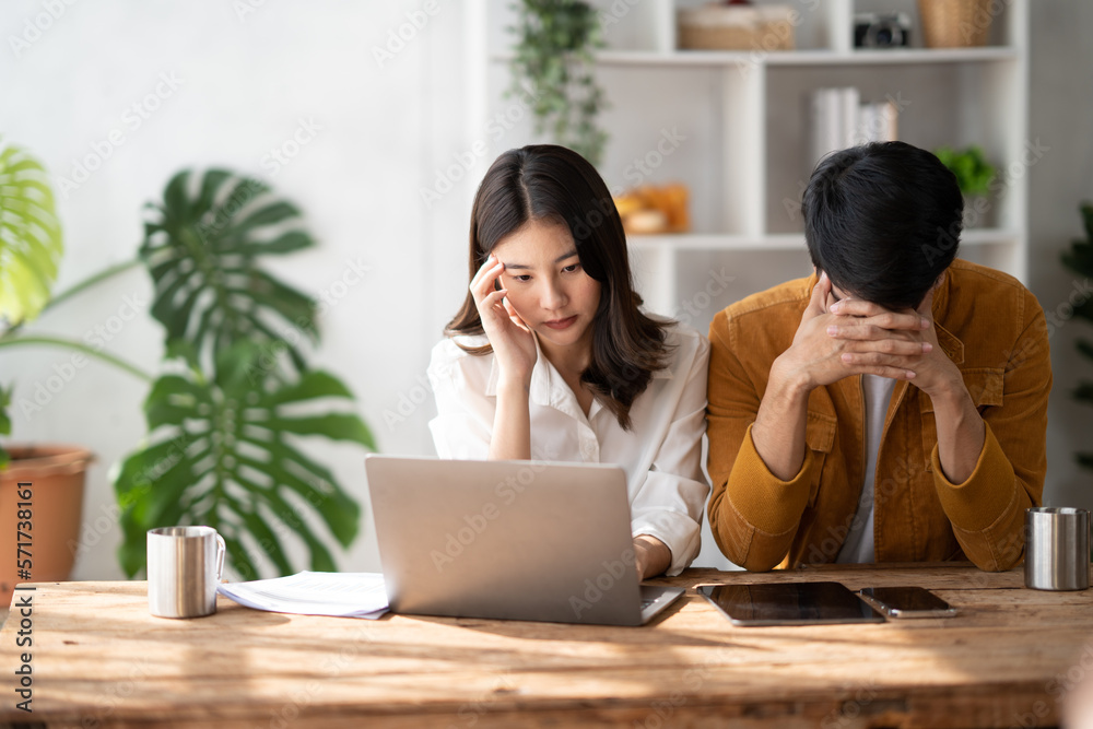 Stress, anxiety and worry with a young couple struggling with finance, debt and the home budget in t