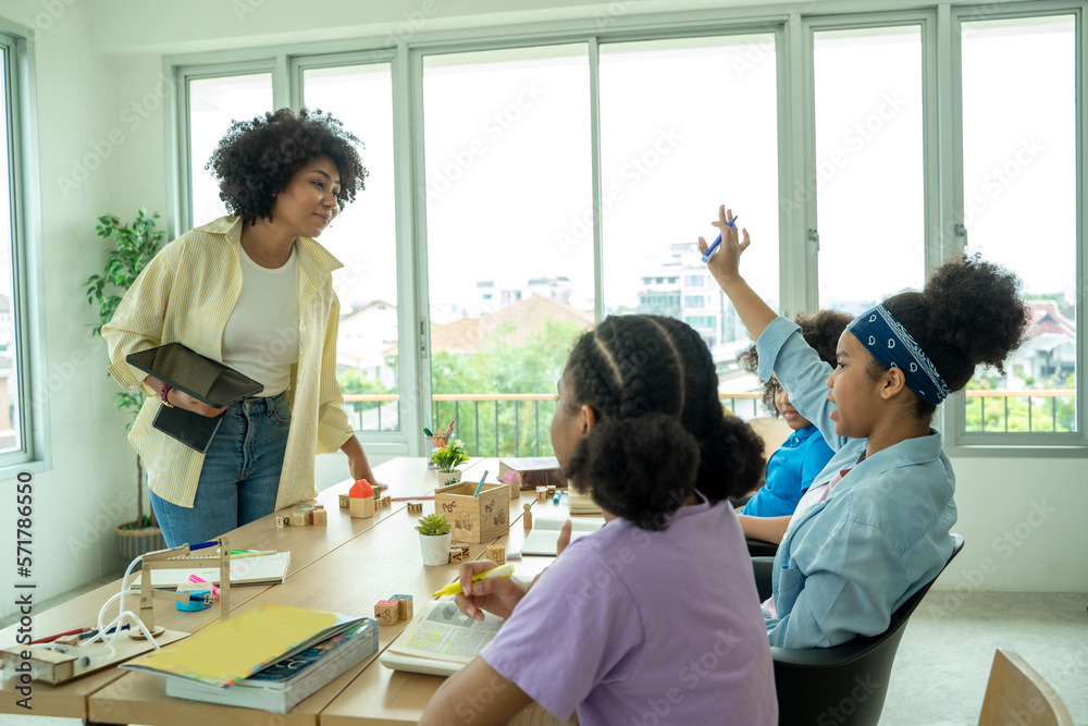 Young African American children sitting at school desk attentively listening to his teacher,Student 